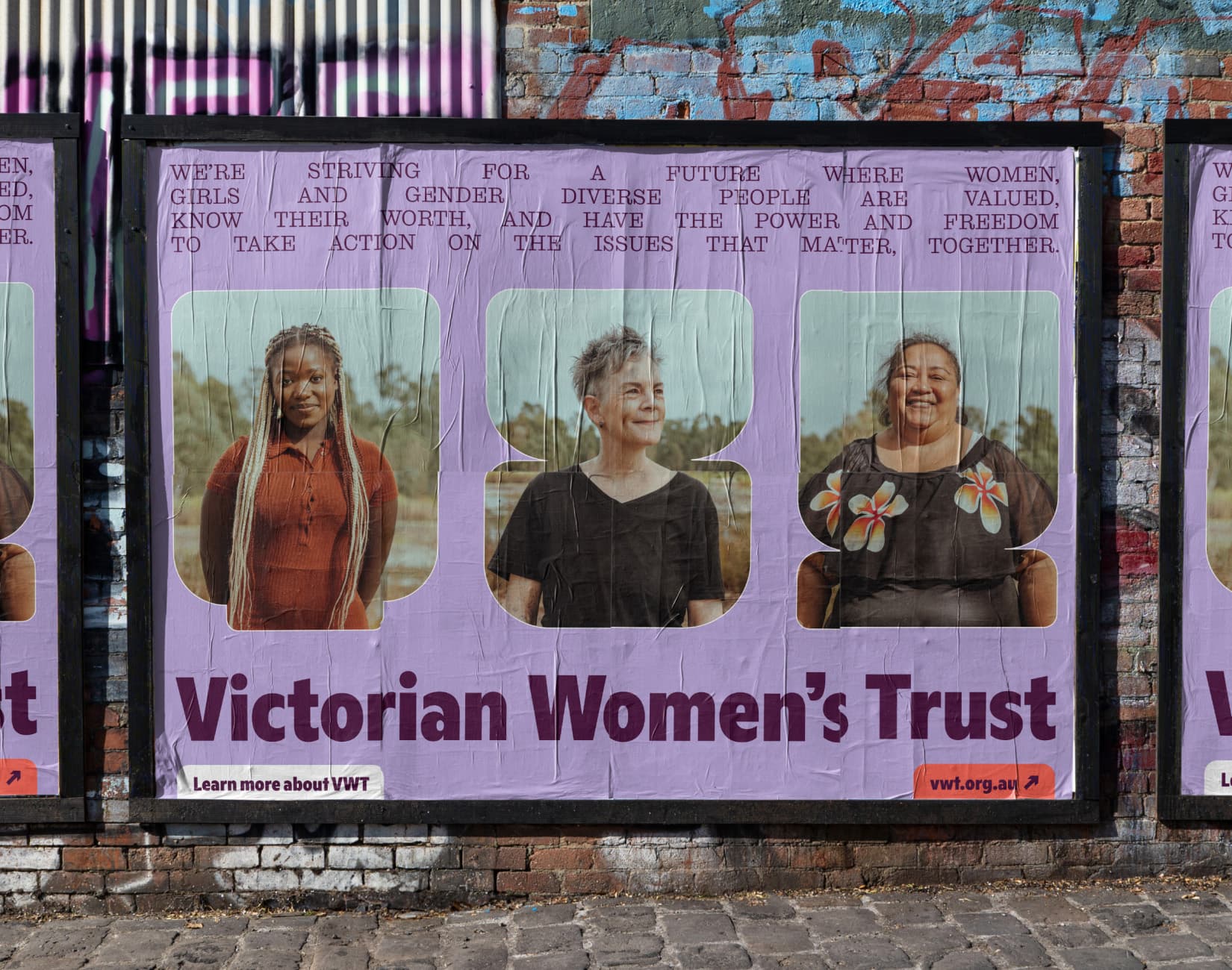 Street posters pasted on a brick wall featuring portraits of women and the Victorian Women’s Trust wordmark